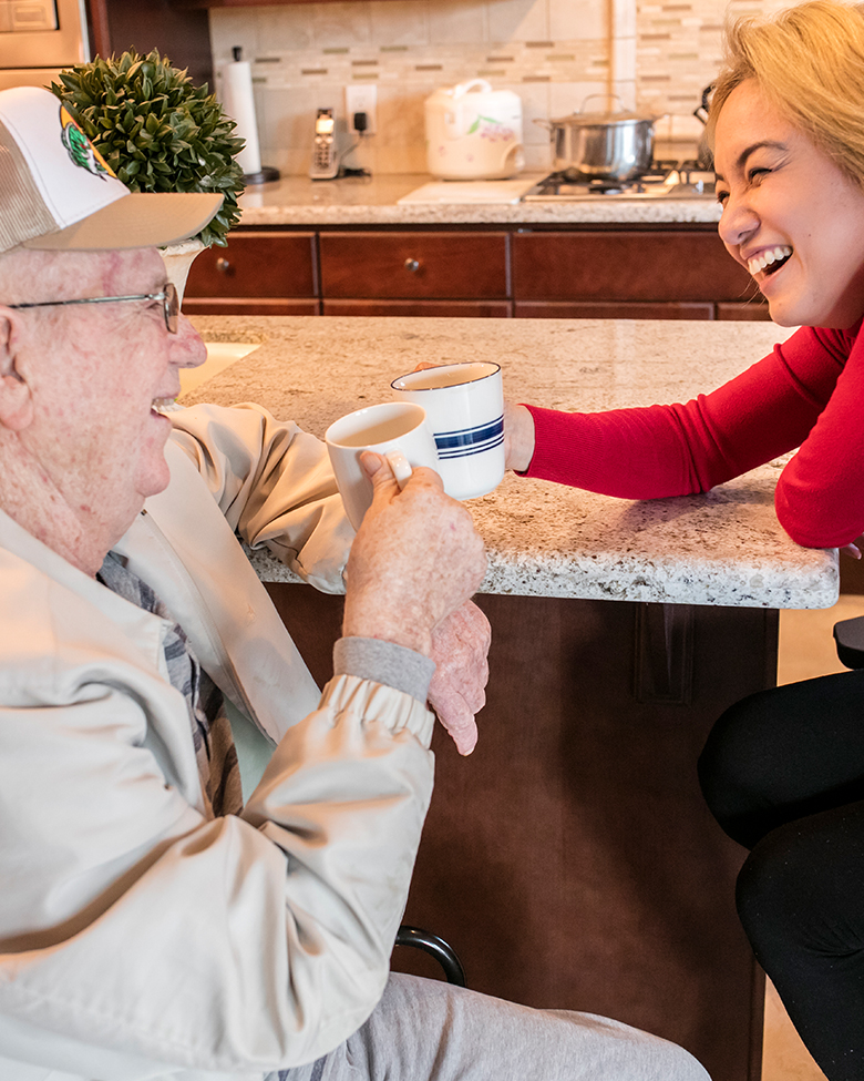 Two people smiling and drinking coffee.