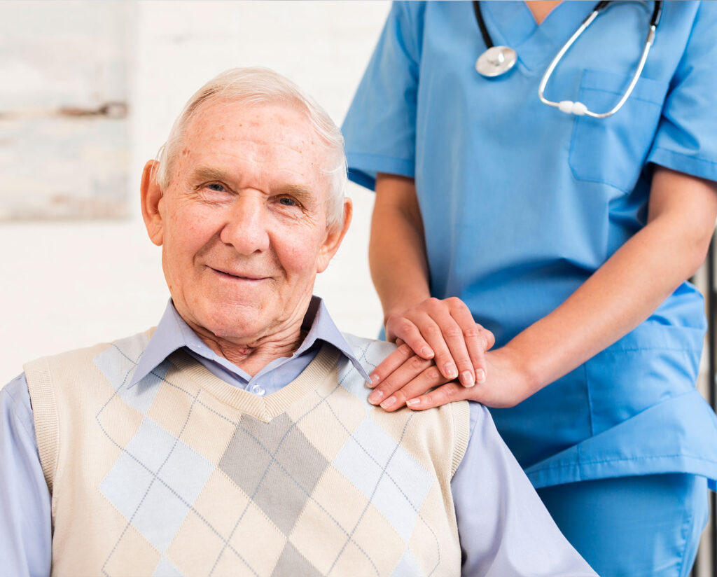 Nurse standing near an elderly man