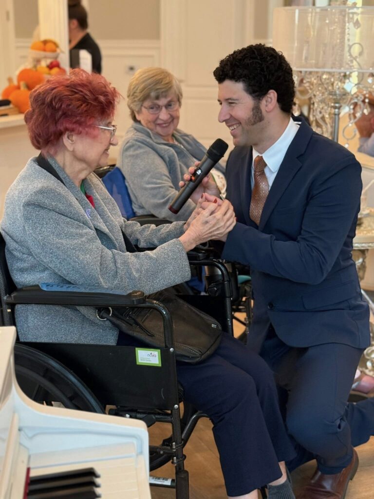 A woman with red hair is being spoken to by a man in a suit.
